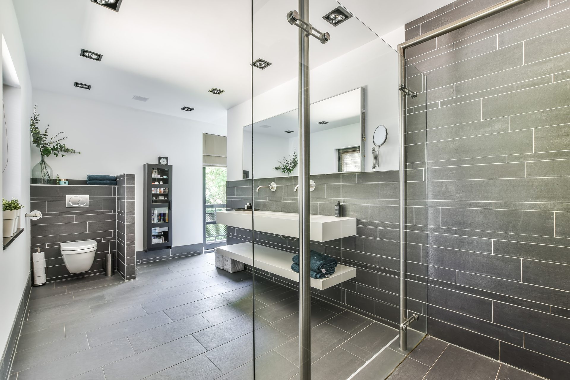 Contemporary bathroom installation in Leeds featuring walk-in shower, grey tiling and modern fittings